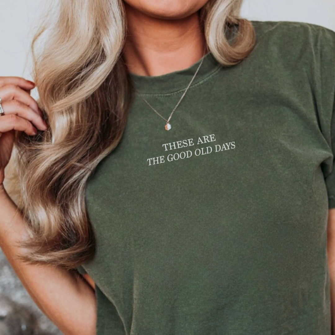 Woman wearing the These Are the Good Old Days Premium Tee, a graphic t-shirt featuring the ‘These Are the Good Old Days’ design.