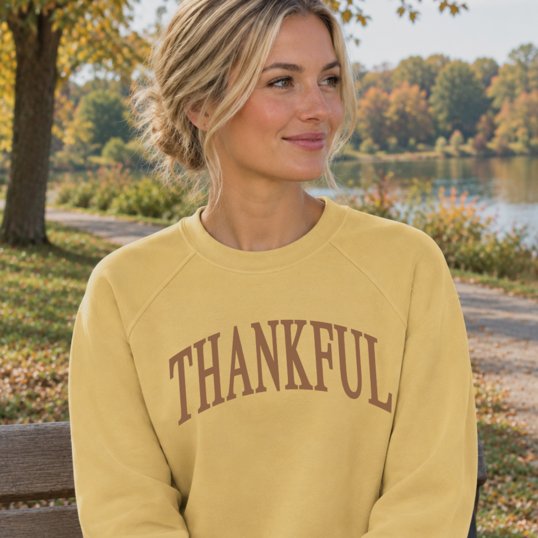 Woman wearing a luxe terry crewneck featuring a large “thankful” graphic across the front.