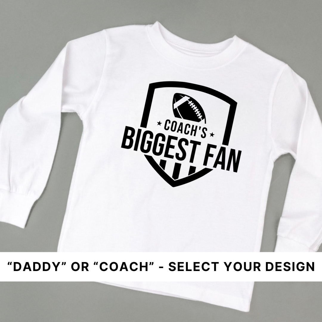 Kids long sleeve tee with fan graphic that says coach's/daddy's biggest fan