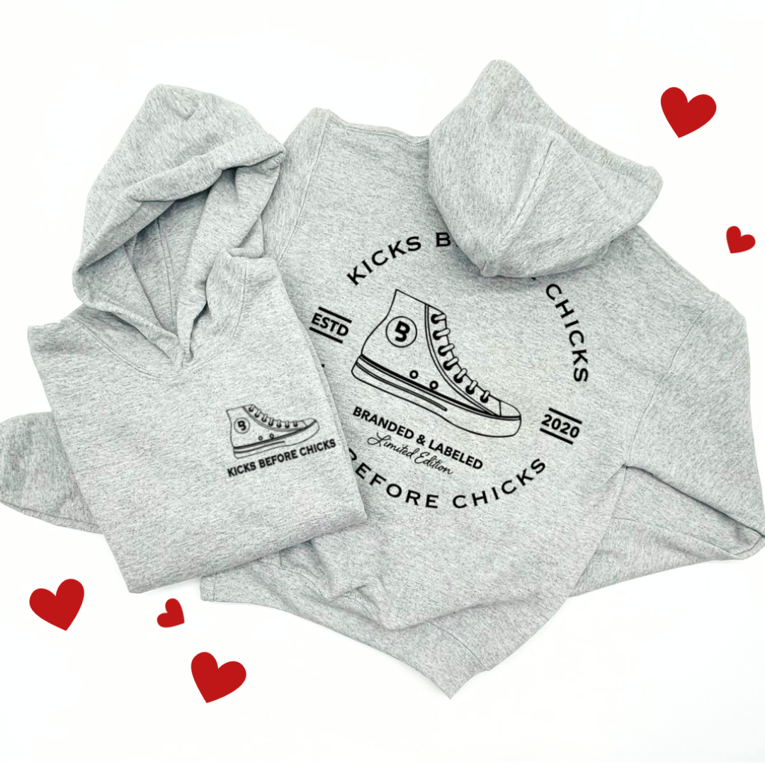 Kids hooded pullover showing a front left chest shoe graphic with ‘Kicks Before Chicks’ text and a large ‘Kicks Before Chicks’ design on the back