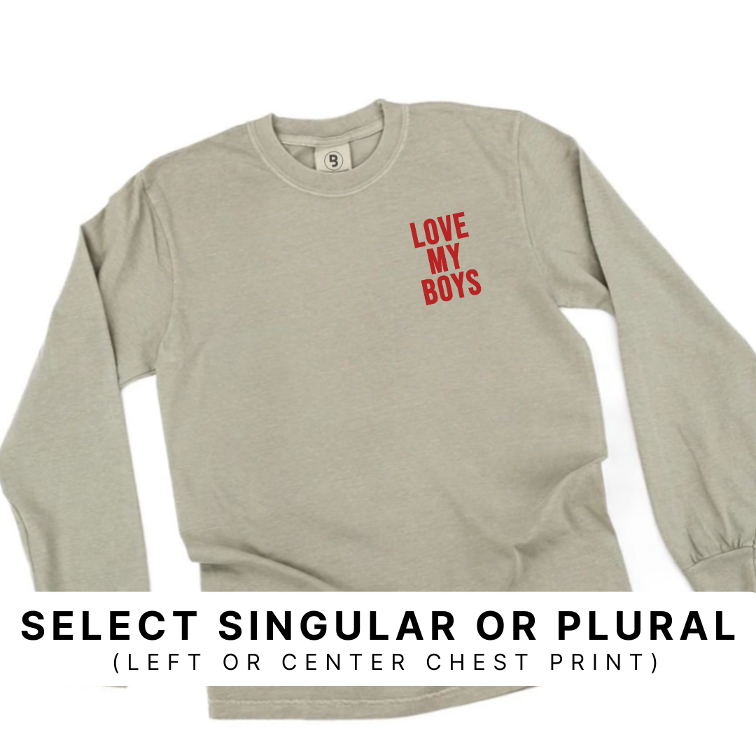 Sandstone garment-dyed premium long sleeve featuring the “Love My Boys” design in red ink printed on the left chest, with a banner indicating options to choose singular or plural wording and left or center chest print placement.