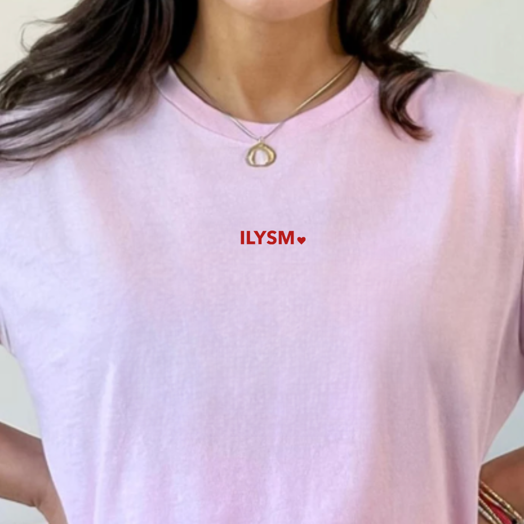 woman wearing pink short sleeve shirt with the ILYSM graphic design