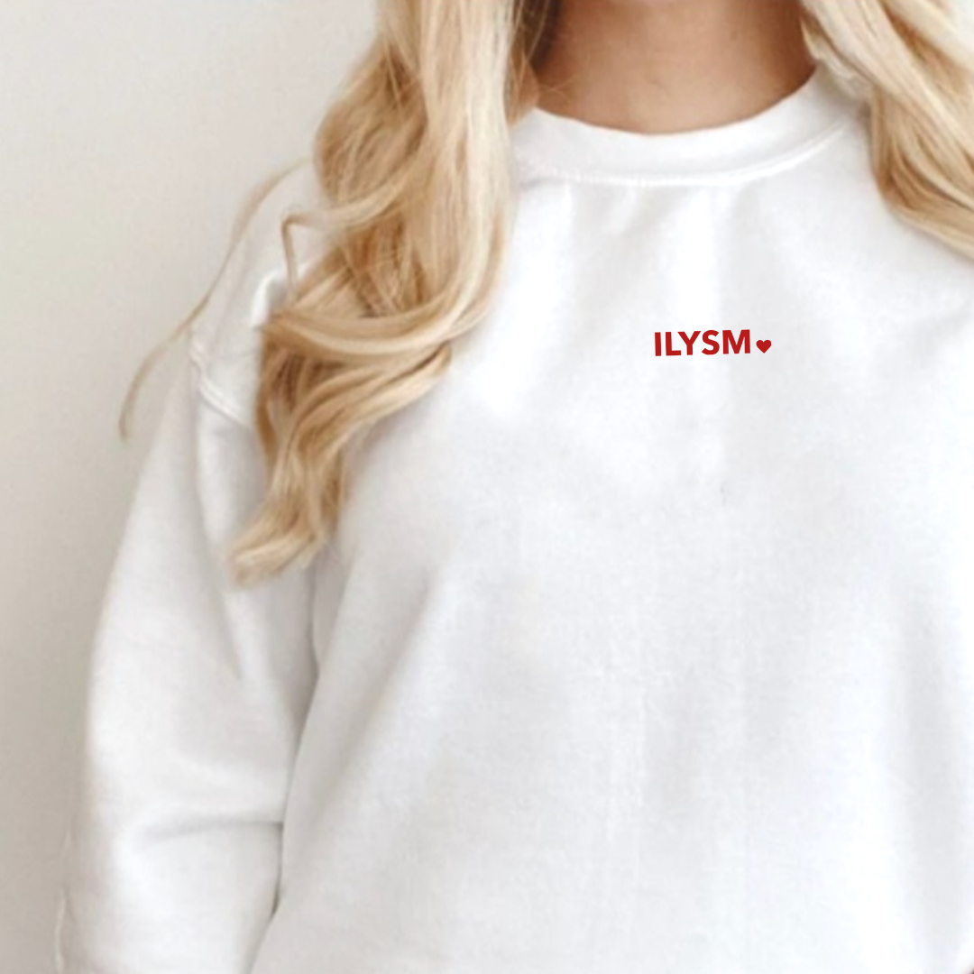 woman wearing a white fleece pullover with the ILYSM graphic design