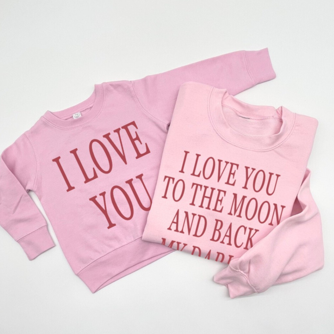 matching set of 2 pink fleece pullovers - one adult and one child, laying side by side with the adult saying "I love you to the moon and back my darlin'" and the kids saying "I love you"