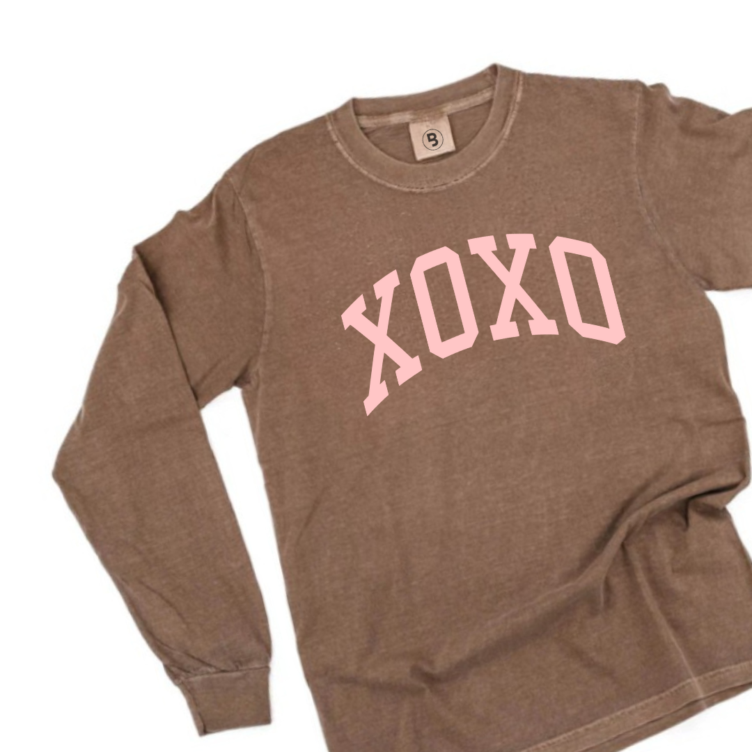 Expresso colored premium long sleeve with a bold XOXO graphic design in pink ink