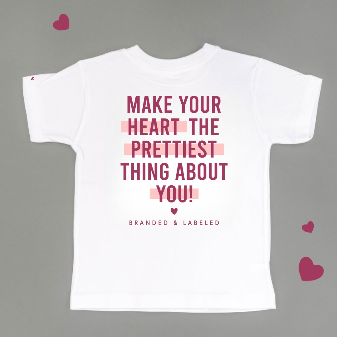 kids white tee with "Make your heart the prettiest thing about you" in bold text font followed by "Branded & Labeled" in a smaller text underneath all printed on the back side of shirt