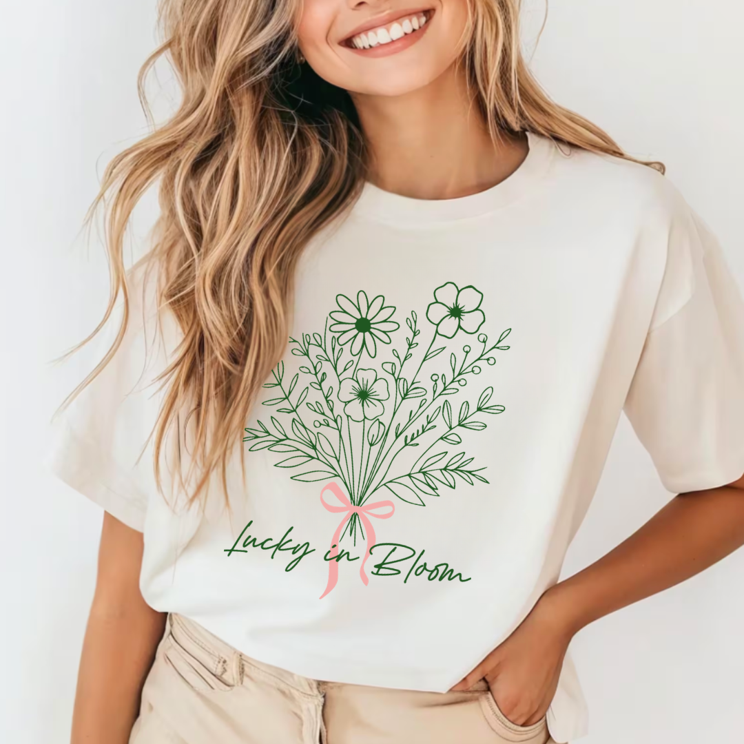 woman standing while modeling a graphic tee with a floral bouquet and "Lucky In Bloom" written underneath it