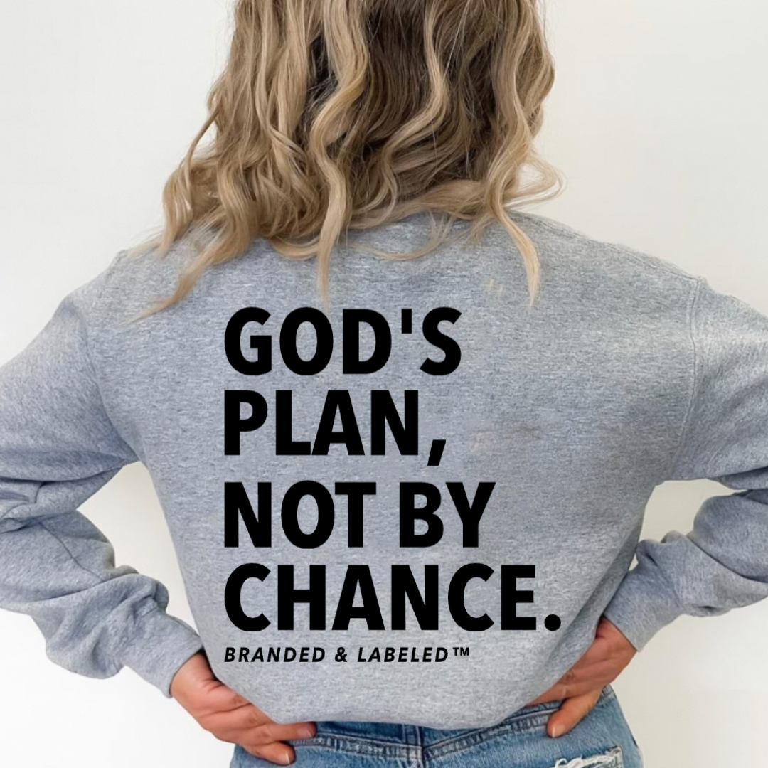 woman modeling a heather light gray fleece with "God's Plan Not By Chance" printed on the back with Branded & Labeled printed subtly underneath