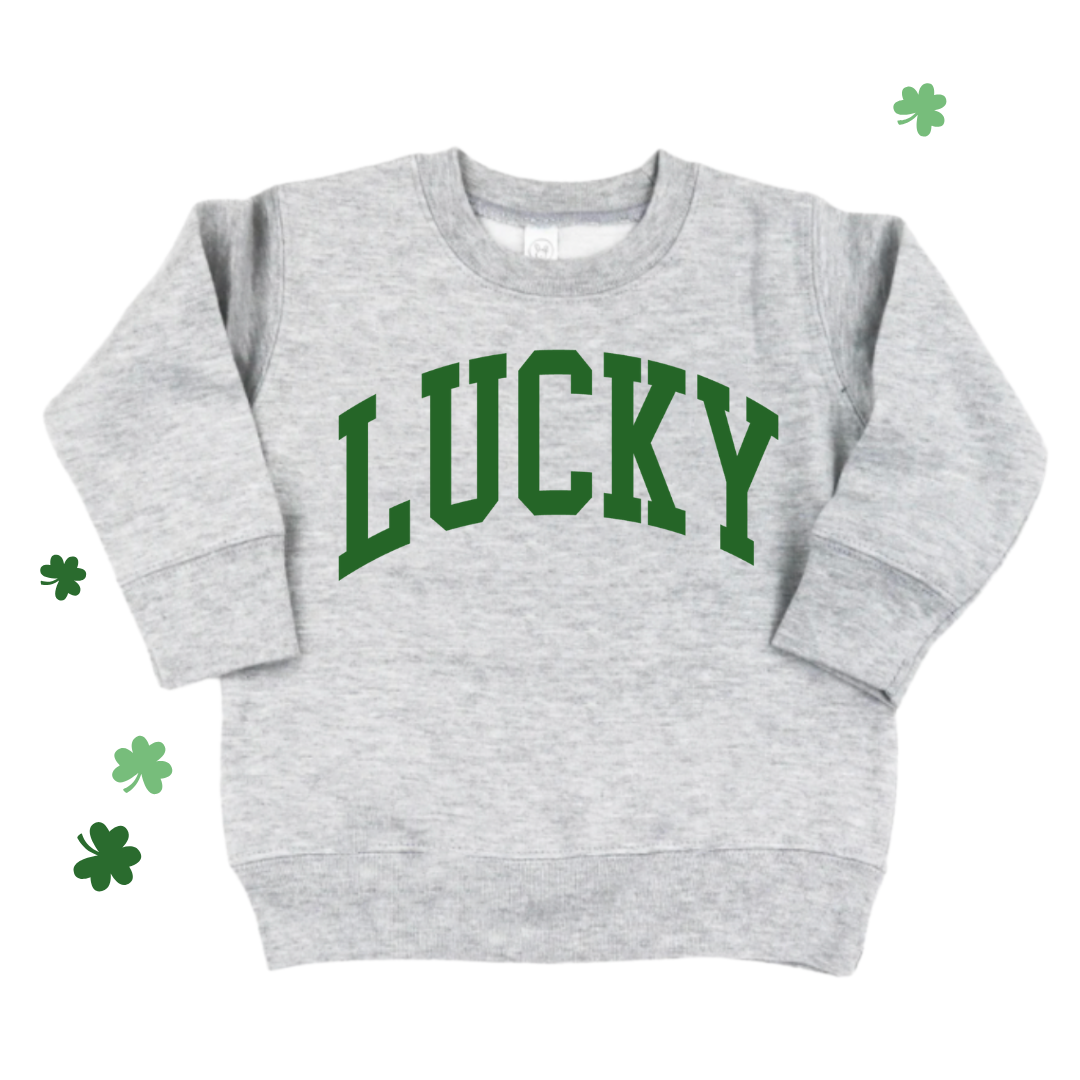 Kids heather light gray fleece pullover with ‘LUCKY’ printed in bold green varsity-style lettering across the front.