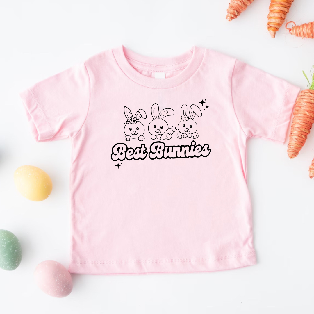 Kids pink Easter graphic tee with “Best Bunnies” design, surrounded by carrots and Easter eggs, a playful spring shirt from Branded & Labeled.