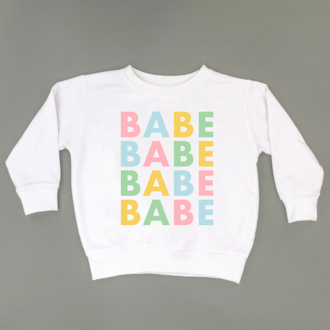 Kids white colored fleece pullover featuring the word “Babe” repeated four times in spring pastel colors printed on the front from the Branded & Labeled spring collection.