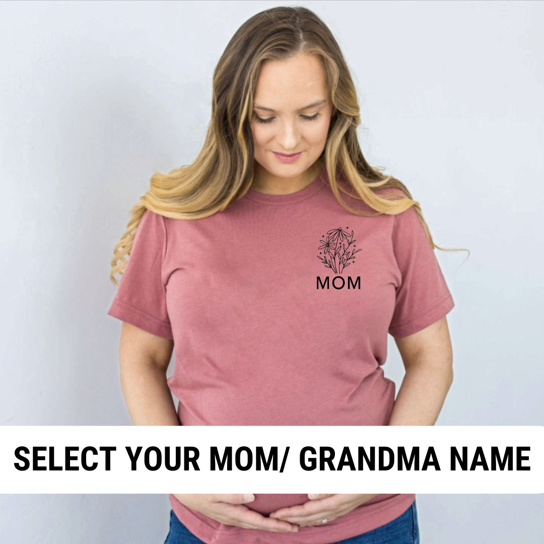 Pregnant woman looking down at her baby bump wearing an everyday tee featuring a floral design with a custom name printed on the left chest.