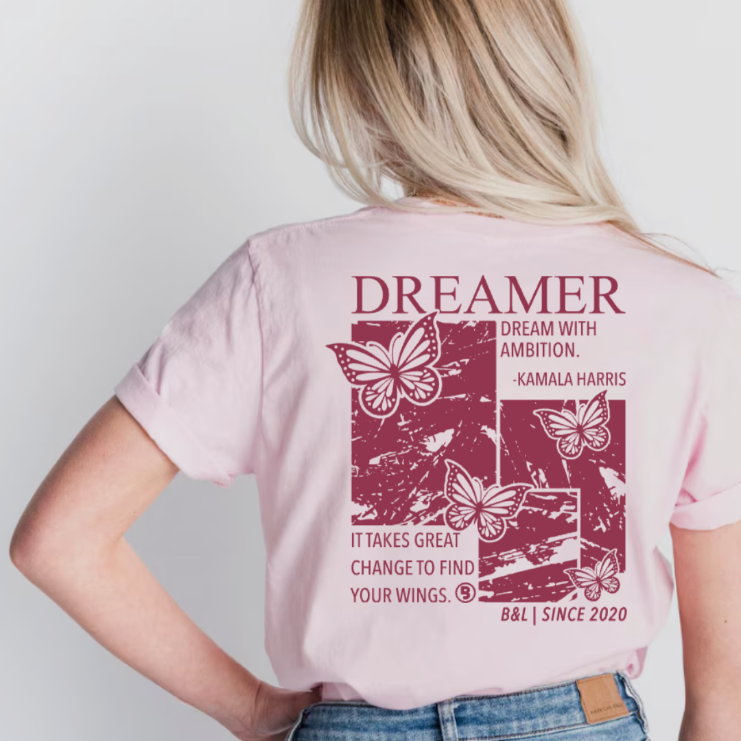 Woman wearing the Dreamer graphic tee by Branded & Labeled, featuring a subtle butterfly detail near the front collar and an inspirational butterfly design on the back.