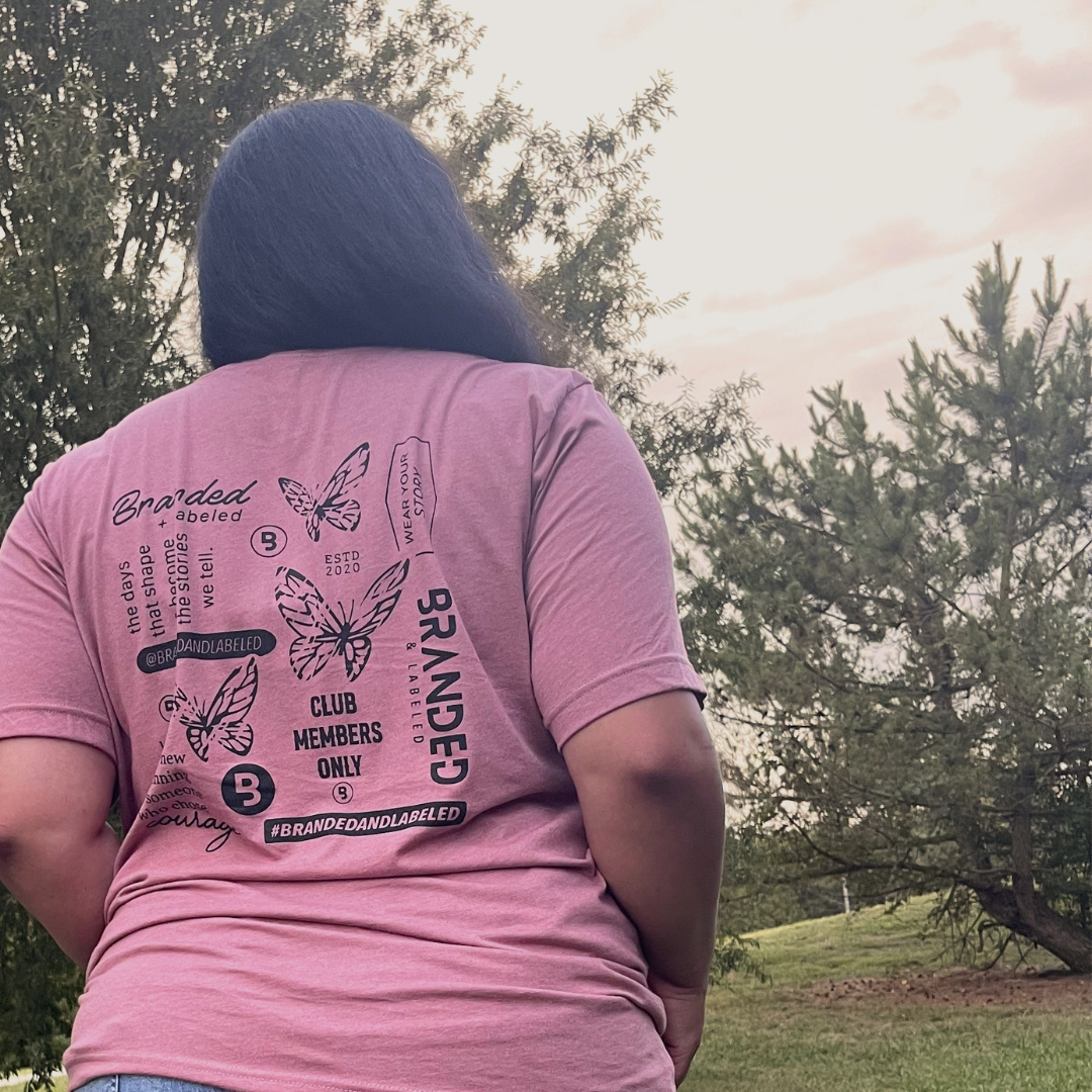 Woman wearing the New Beginnings adult tee from Branded & Labeled featuring a collage of meaning quotes, butterflies, and logo variations for Branded & Labeled