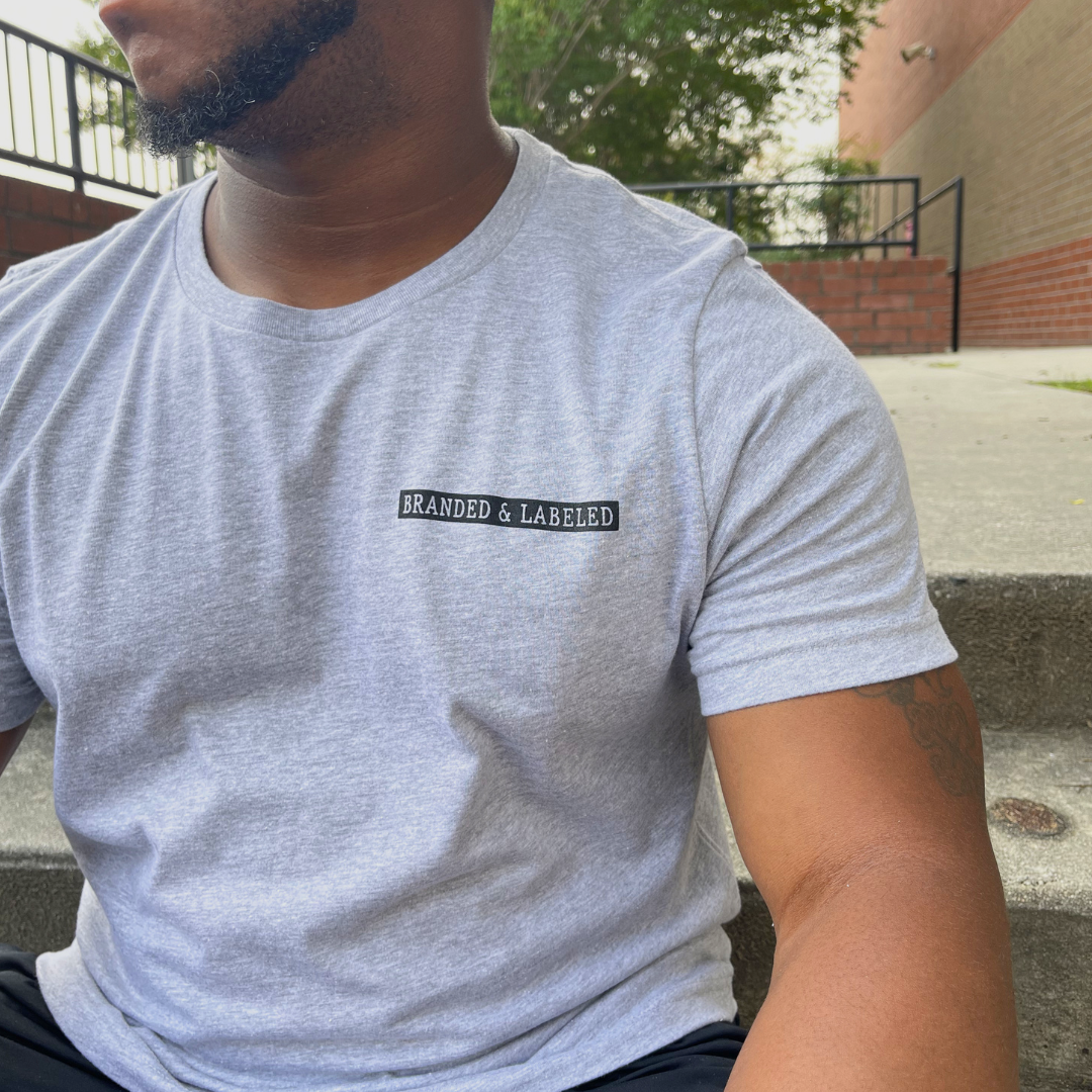 Adult man wearing the Origins graphic tee from Branded & Labeled, showcasing the design on a comfortable everyday shirt.