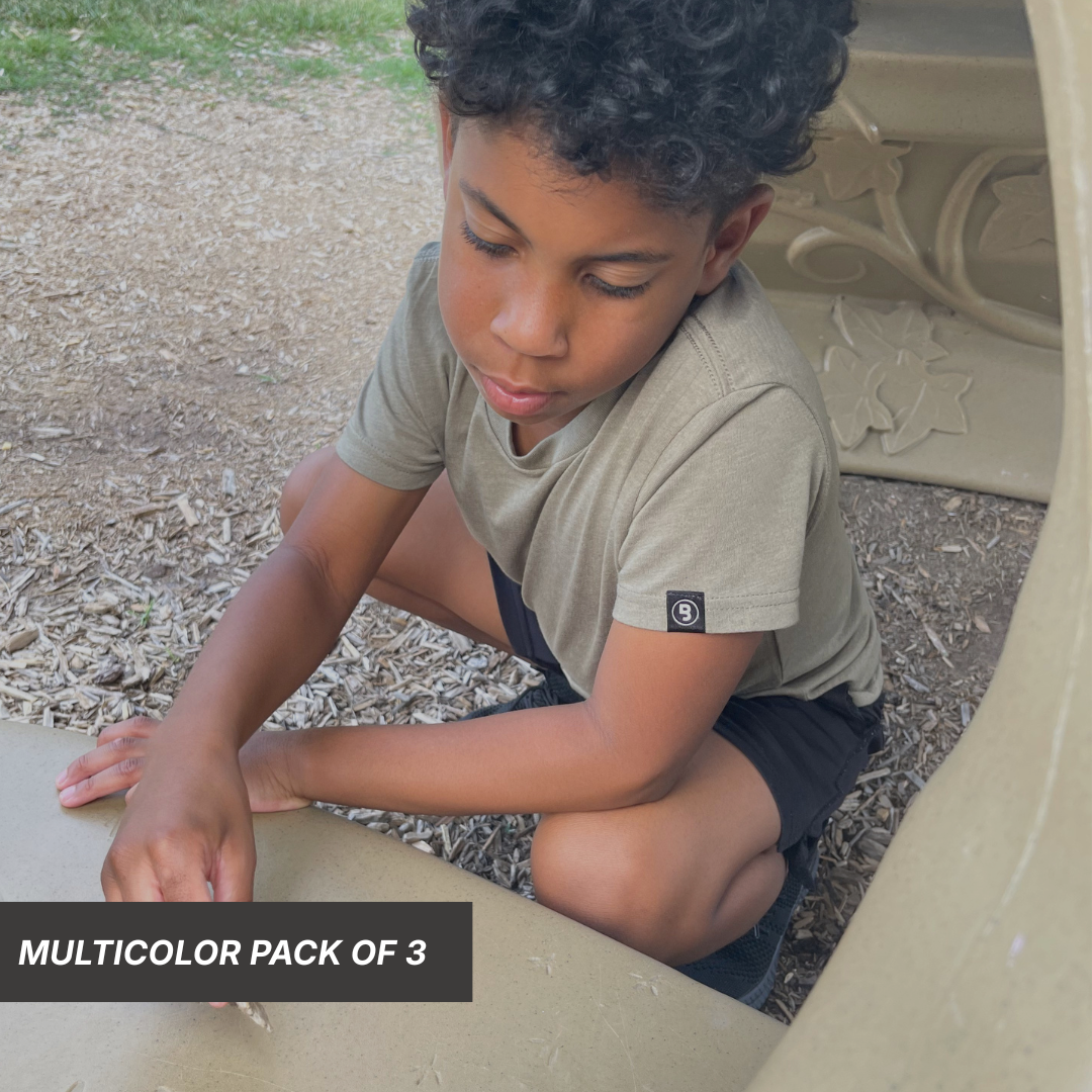 Young boy wearing an olive Premium Signature Collection kids tee featuring a clean front and signature Branded & Labeled sewn-on logo label on the left sleeve.
