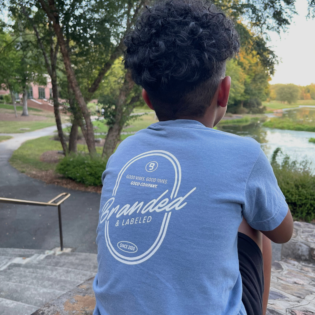 Young boy wearing the Good Company Youth Premium Tee, a kids graphic t-shirt featuring the Good Vibes Good Times Good Company design from Branded & Labeled