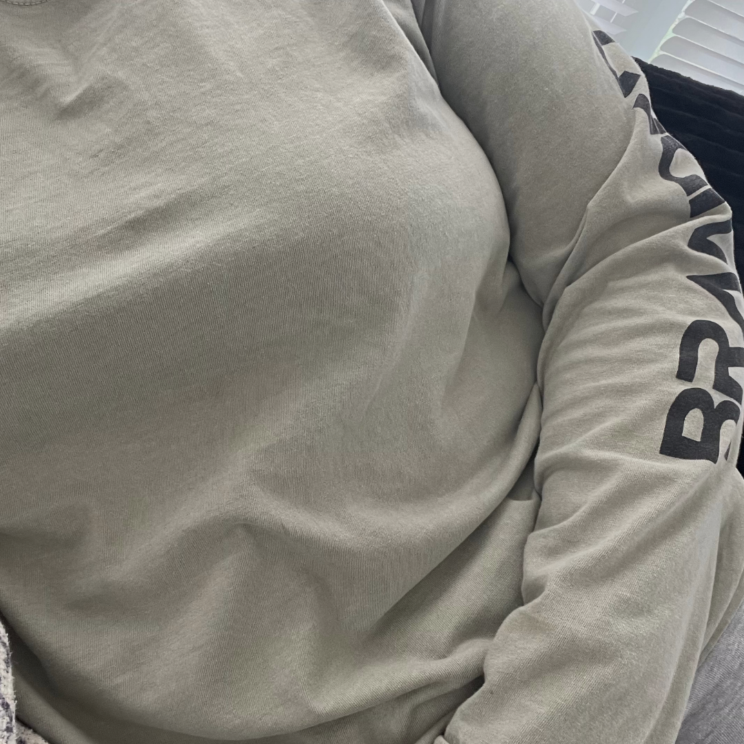 Adult wearing the Sandstone Branded Premium Long Sleeve, a garment-dyed unisex shirt featuring BRANDED printed down the left sleeve.